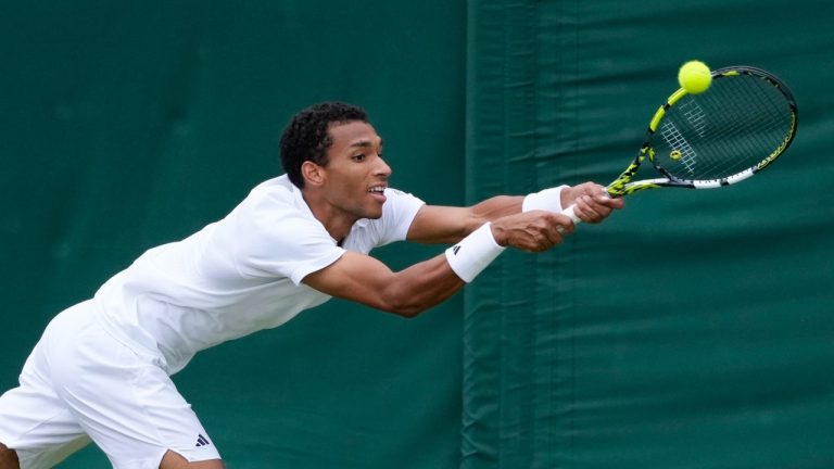 Felix Auger-Aliassime of Canada plays a backhand return to Thanasi Kokkinakis of Australia during their match on day three at Wimbledon, July 3, 2024. (AP Photo/Kirsty Wigglesworth)