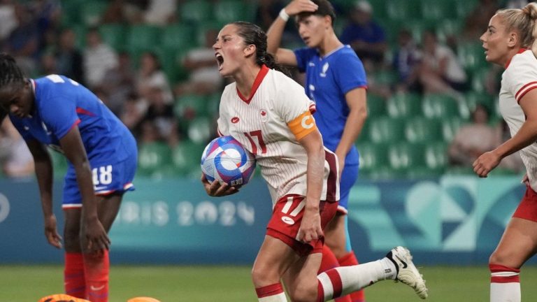 Canada's Jessie Fleming holds the ball as she celebrates after scoring her side's opening goal during the women's Group A soccer match between Canada and France at Geoffroy-Guichard stadium during the 2024 Summer Olympics, Sunday, July 28, 2024, in Saint-Etienne, France. (CP/AP-Silvia Izquierdo)