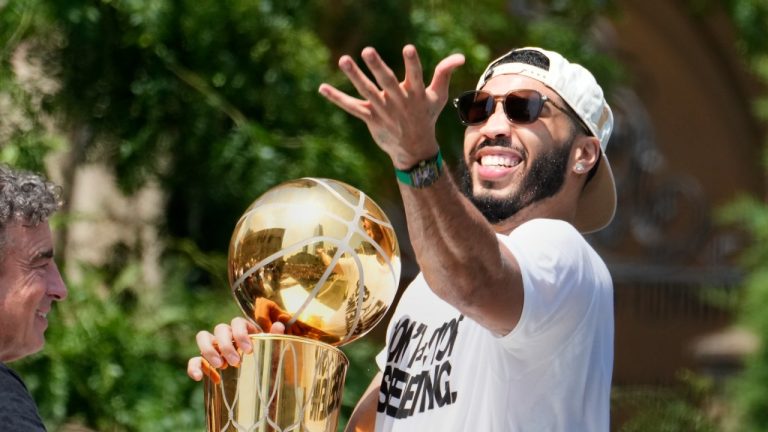 Boston Celtics' Jayson Tatum, right, and Celtics owner Wyc Grousbeck, center, celebrate their NBA championship with a duck boat parade, June 21, 2024. (AP Photo/Michael Dwyer)