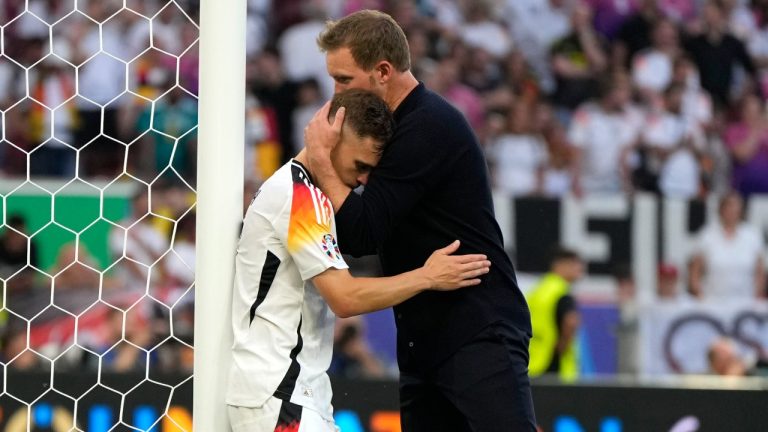 Germany's Joshua Kimmich is hugged by head coach Julian Nagelsmann at the end of a quarter final match against Spain at the Euro 2024 tournament, July 5, 2024. (AP Photo/Matthias Schrader)