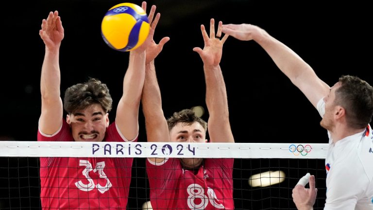 Canada's Fynnian Lionel Mccarthy, left, and Canada's Eric Loeppky block a ball during the group A men's volleyball match between Slovenia and Canada at the 2024 Summer Olympics, Sunday, July 28, 2024, in Paris, France. (Alessandra Tarantino/AP)