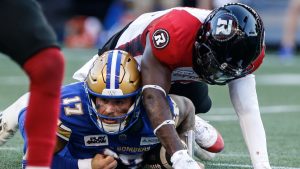 Winnipeg Blue Bombers quarterback Chris Streveler (17) gets tackled by Ottawa Redblacks' Adarius Pickett (6) during first half CFL action in Winnipeg, July 5, 2024. (THE CANADIAN PRESS/John Woods)