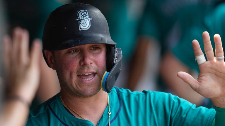 Ty France is congratulated in the dugout after scoring in the fifth inning of a baseball game against the Cleveland Guardians, Thursday, June 20, 2024, in Cleveland. (Sue Ogrocki/AP)