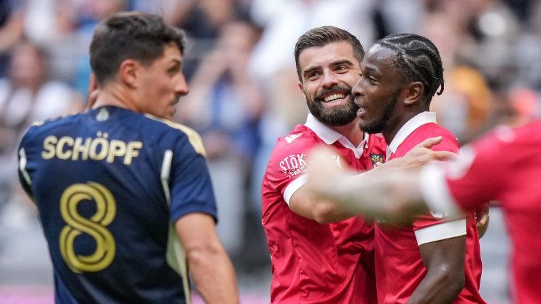 Wrexham's Sebastian Revan, back right, and Elliot Lee celebrate Revan's goal as Vancouver Whitecaps' Alessandro Schopf (8) looks on during the first half of an international friendly soccer match, in Vancouver, on Saturday, July 27, 2024. THE CANADIAN PRESS/Darryl Dyck