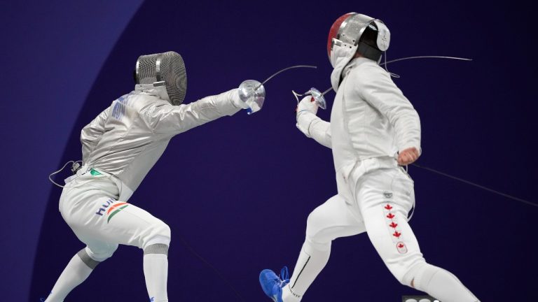 Hungary's Aron Szilagyi, left, and Canada's Fares Arfa compete in the men's individual Sabre round of 32 competition during the 2024 Summer Olympics at the Grand Palais, Saturday, July 27, 2024, in Paris, France. (Andrew Medichini/AP Photo)