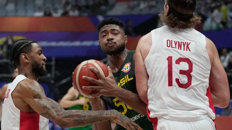 Brazil forward Bruno Caboclo (50) drives against Canada forward Kelly Olynyk (13) and Canada guard Nickeil Alexander-Walker (1) during the Basketball World Cup second round match between Canada and Brazil at the Indonesia Arena stadium in Jakarta, Indonesia, Friday, Sept. 1, 2023. (Dita Alangkara/AP Photo)