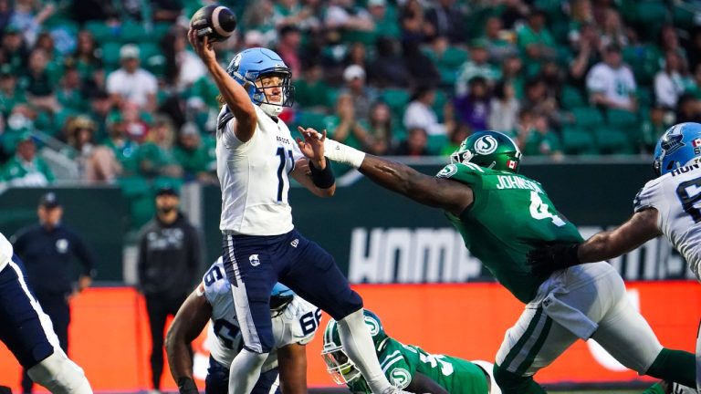 Toronto Argonauts quarterback Cameron Dukes (11) throws under pressure from Saskatchewan Roughriders' Micah Johnson (4) during the second half of CFL football action in Regina, on Thursday, July 4, 2024. (Heywood Yu/CP)