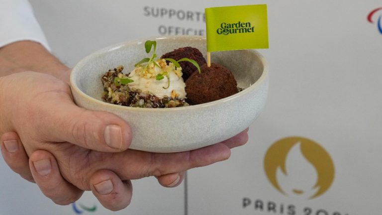 A member of Garden Gourmet displays a falafel, quinoa and humus salad dish during a presentation of a veggie food line at the headquarters of the Paris 2024 Olympics Games in Paris, Tuesday Dec. 12, 2023. (Michel Euler/AP Photo)