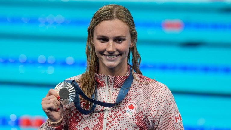 Summer McIntosh, of Canada, smiles as she holds her silver medal after the women's 400-meter freestyle final at the 2024 Summer Olympics, Saturday, July 27, 2024, in Nanterre, France. (Adrian Wyld/THE CANADIAN PRESS)