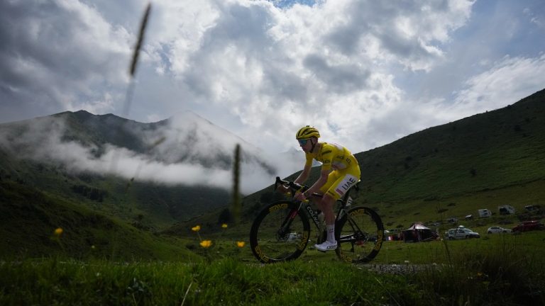 Slovenia's Tadej Pogacar, wearing the overall leader's yellow jersey, speeds downhill during the fourteenth stage of the Tour de France cycling race over 151.9 kilometres (94.4 miles) with start in Pau and finish in Saint-Lary-Soulan Pla d'Adet, France, Saturday, July 13, 2024. (Daniel Cole/AP)