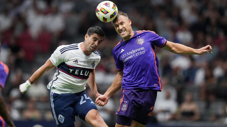 Vancouver Whitecaps' Brian White, left, and Houston Dynamo's Erik Sviatchenko vie for the ball during the second half of an MLS soccer match, in Vancouver, on Saturday, July 20, 2024. (Darryl Dyck/CP)