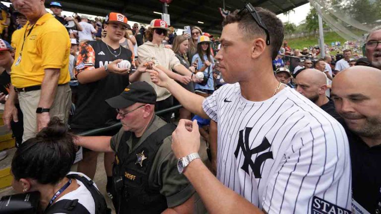 New York Yankees' Aaron Judge, right, makes his way to his seat at Lamade Stadium during a team visit to the Little League World Series tournament in South Williamsport, Pa., Sunday, Aug. 18, 2024. The Yankees will be playing the Detroit Tigers in the Little League Classic at Bowman Stadium in Williamsport, Pa., on Sunday Night Baseball. (Gene J. Puskar/AP)