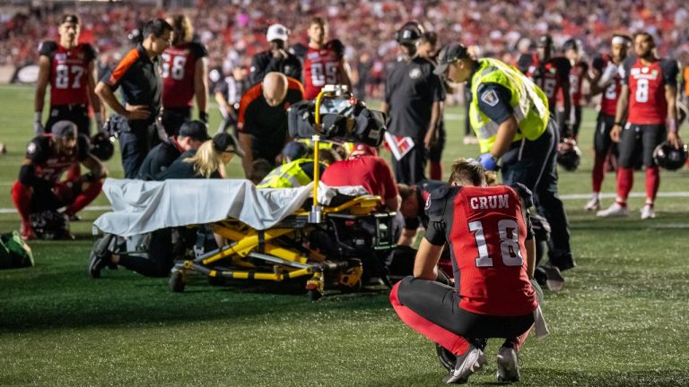 Ottawa Redblacks quarterback Dustin Crum (18) looks on as his injured teammate Jaelon Acklin (23) is tended to by medical personnel during second half CFL football action against the B.C. Lions in Ottawa, on Saturday, August 24, 2024. (Chris Tanouye/CP)