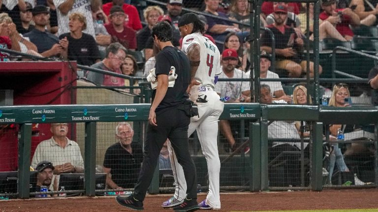 Arizona Diamondbacks' Ketel Marte (4) is walked off the field by head athletic trainer Ryan DiPanfilo, left, after a collision at second base with Philadelphia Phillies' Garrett Stubbs during the fourth inning of a baseball game Saturday, Aug 10, 2024, in Phoenix. (Darryl Webb/AP)