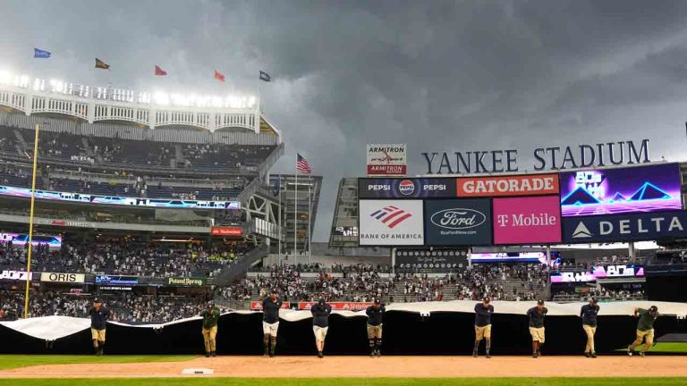 Members of the ground crew cover the field during a rain delay in the eighth inning of a baseball game between the New York Yankees and the Toronto Blue Jays at Yankee Stadium, Sunday, Aug. 4, 2024, in New York. (Seth Wenig/AP)