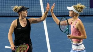 Gabriela Dabrowski, left, of Ottawa, high fives teammate Erin Routliffe, of New Zealand, after winning a game in the second set against Leylah Fernandez, of Montreal, and teammate and sister Bianca Fernandez, during women's doubles semifinal action against at the National Bank Open, in Toronto, Sunday, Aug. 11, 2024. (Frank Gunn/CP)