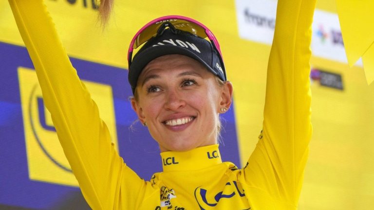 Katarzyna Niewiadoma of Poland, wearing the overall leader's yellow jersey, celebrates on the podium after the seventh stage of the Tour de France Women cycling race with start in Champagnole and finish in Le Grand-Bornand, France, Saturday, Aug. 17, 2024. (AP/Peter Dejong)