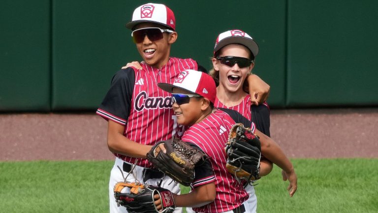 Canada's Ronan Babiles, left, celebrates with Kayden Krestanovich, right, and Rye Precioso, center, after getting the final out of a 12-5 win over Puerto Rico in a baseball game at the Little League World Series in South Williamsport, Pa., Saturday, Aug. 17, 2024. (Gene J. Puskar/AP Photo)