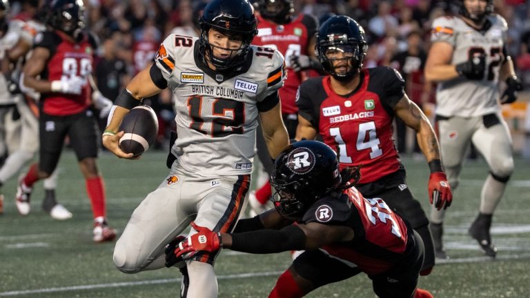 B.C. Lions quarterback Nathan Rourke (12) avoids a tackle by Ottawa Redblacks' Deandre Lamont (38) during first half CFL football action in Ottawa on Saturday, August 24, 2024. (Chris Tanouye/CP)