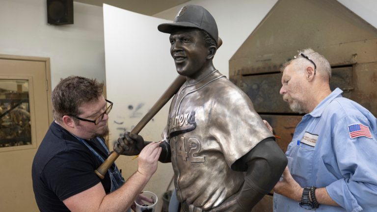 Nate Ford, left, and Jeff Herndon apply finishing touches to a statue of baseball hall-of-famer and civil rights pioneer Jackie Robinson in Loveland, Colo., on Wednesday, July 24, 2024. (Travis Heying/The Wichita Eagle via AP)