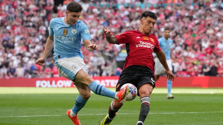 Manchester City's Julian Alvarez, left, attempts a shot at goal in front of Manchester United's Lisandro Martinez during the English FA Cup final soccer match between Manchester City and Manchester United at Wembley Stadium in London, Saturday, May 25, 2024. (Kin Cheung/AP)