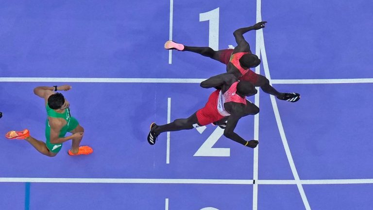 Emmanuel Wanyonyi, of Kenya, top, crosses the finish line ahead of Marco Arop, of Canada, to win the men's 800-metre final at the 2024 Summer Olympics, Saturday, Aug. 10, 2024, in Saint-Denis, France. (David J. Phillip/AP Photo)