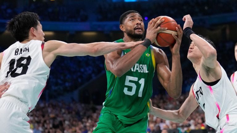 Bruno Caboclo, of Brazil shoots between Yudai Baba, left, and Yuta Watanabe, of Japan, in a men's basketball game at the 2024 Summer Olympics, Friday, Aug. 2, 2024, in Villeneuve-d'Ascq, France. (Mark J. Terrill/AP Photo)