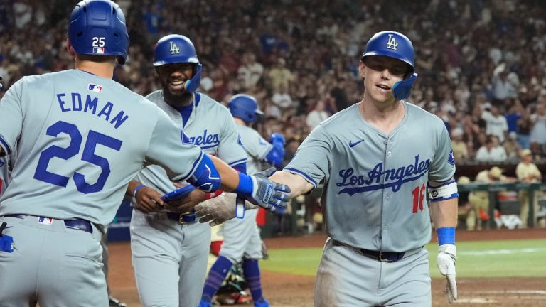 Los Angeles Dodgers' Will Smith, right, celebrates his three-run home run against the Arizona Diamondbacks with Dodgers' Tommy Edman (25) and Teoscar Hernández, second from left, during the seventh inning of a baseball game Friday, Aug. 30, 2024, in Phoenix. (Ross D. Franklin/AP)