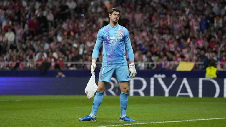 Real Madrid's goalkeeper Thibaut Courtois holds a bag, thrown by Atletico Madrid fans, during the La Liga soccer match between Atletico Madrid and Real Madrid at the Metropolitano stadium in Madrid, Spain, Sunday, Sept. 29, 2024. (Bernat Armangue/AP)