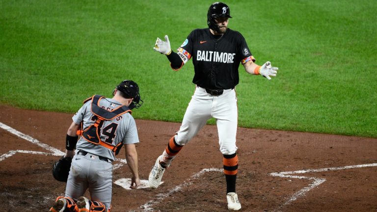 Baltimore Orioles' Colton Cowser, top, celebrates his home run during the sixth inning of a baseball game as Detroit Tigers catcher Jake Rogers looks on, at bottom, Friday, Sept. 20, 2024, in Baltimore. (AP Photo/Nick Wass)