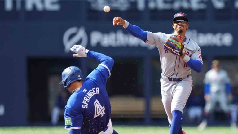 Toronto Blue Jays designated hitter George Springer grounds out at second in front of New York Mets shortstop Francisco Lindor during first inning interleague MLB baseball action in Toronto, Wednesday, Sept. 11, 2024. (Chris Young/CP)