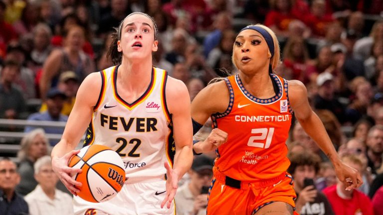 Indiana Fever guard Caitlin Clark (22) shoots in front of Connecticut Sun guard DiJonai Carrington (21) in the second half of a WNBA basketball game in Indianapolis, Monday, May 20, 2024. (Michael Conroy/AP Photo)