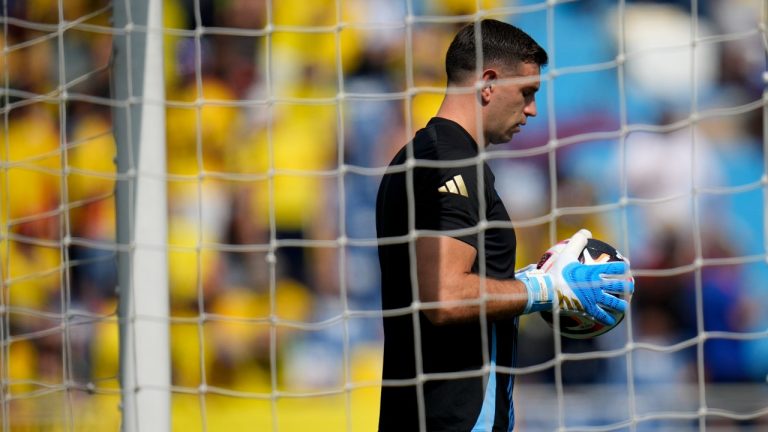 Argentina's goalkeeper Emiliano Martinez holds a ball while warming up prior to a qualifying soccer match against Colombia for the FIFA World Cup 2026 at the Metropolitano Roberto Melendez stadium in Barranquilla, Colombia, Tuesday, Sept. 10, 2024. (AP)