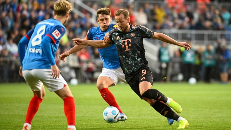 Kiel's Nicolai Remberg, left, challenges Bayern's Harry Kane during the German Bundesliga soccer match between Holstein Kiel and Bayern Munich, at the Holsten stadium in Kiel, Germany, Saturday, Sept. 14, 2024. (Gregor Fischer/dpa via AP)