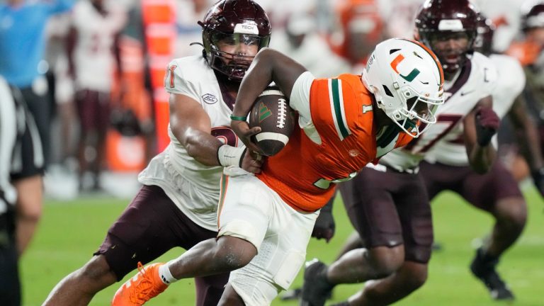 Virginia Tech defensive lineman Wilfried Pene (91) grabs Miami quarterback Cam Ward (1) during the first half of an NCAA college football game, Friday, Sept. 27, 2024, in Miami Gardens, Fla. (AP Photo/Marta Lavandier)