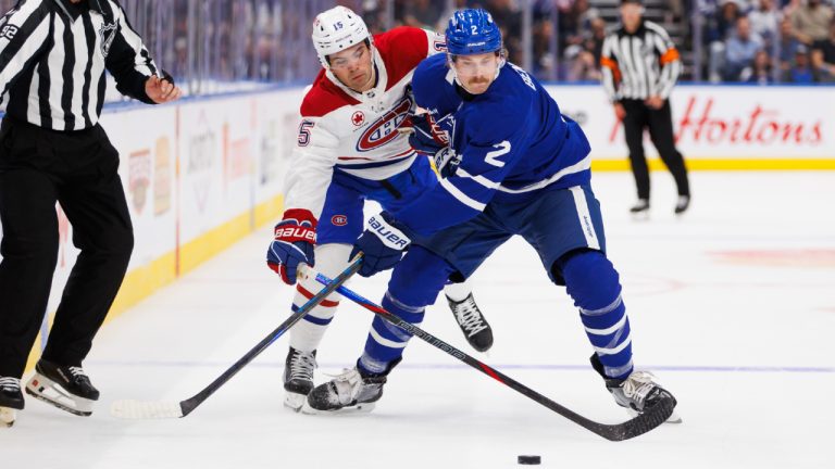 Montreal Canadiens centre Alex Newhook (15) and Toronto Maple Leafs defenceman Simon Benoit (2) vie for the puck during first period pre-season NHL hockey action in Toronto on Thursday, September 26, 2024. (Cole Burston/CP)