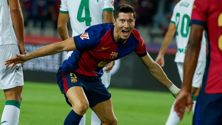 Barcelona's Robert Lewandowski, center, celebrates with Barcelona's Jules Kounde, front, after scoring the opening goal during a Spanish La Liga soccer match between Barcelona and Getafe at the Olympic stadium in Barcelona, Spain, Wednesday, Sept. 25, 2024. (AP Photo/Joan Monfort)