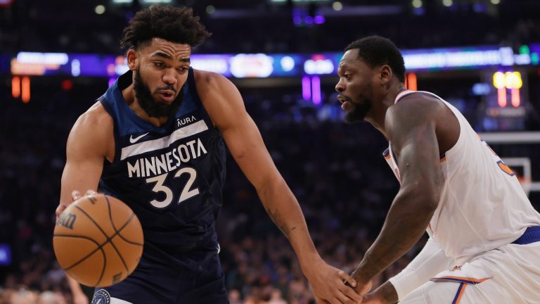 Minnesota Timberwolves center Karl-Anthony Towns (32) drives around New York Knicks forward Julius Randle during the first half of an NBA basketball game Monday, Jan. 1, 2024, in New York. (AP Photo/Adam Hunger)