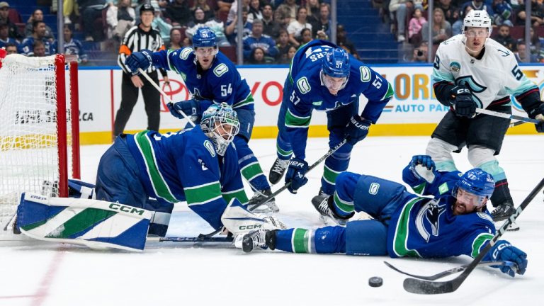 Vancouver Canucks goaltender Arturs Silovs (31), Filip Hronek (17), Aatu Raty (54) and Tyler Myers (57) watch a shot from Seattle Kraken's Jaden Schwartz, not seen, as Ben Meyers (59) watches during second period NHL pre-season hockey action in Vancouver, on Tuesday, September 24, 2024. (Ethan Cairns/CP)