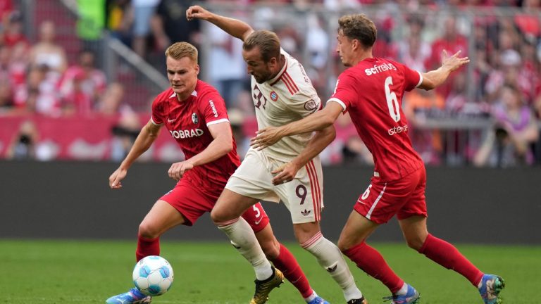 Bayern's Harry Kane, centre, fights for the ball with Freiburg's Philipp Lienhart, left, and Patrick Osterhage during the Bundesliga soccer match between Bayern Munich and SC Freiburg at the Allianz Arena in Munich, Germany, Sunday, Sept. 1, 2024. (Matthias Schrader/AP)