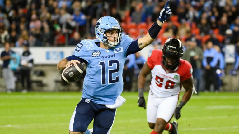 Toronto Argonauts quarterback Chad Kelly (12) runs the ball under pressure by Ottawa Redblacks defensive lineman Bryce Carter (58) during first half CFL action against the Ottawa Redblacks, in Toronto, Saturday, Oct. 14, 2023. (Christopher Katsarov/THE CANADIAN PRESS)