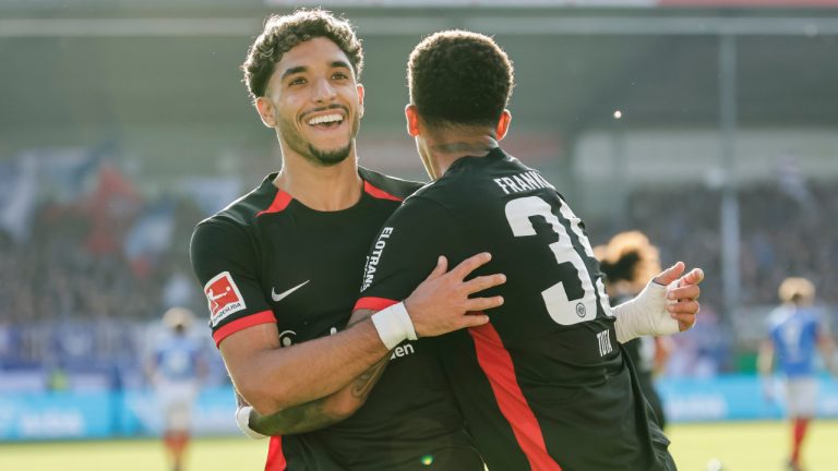 Frankfurt's Omar Marmoush, left, and Lucas Tuta-Silva Melo celebrate after scoring their side's fourth goal during the Bundesliga soccer match between Holstein Kiel and Eintracht Frankfurt, at the Holstein Stadium in Kiel, Germany, Sunday, Sept. 29, 2024. (Frank Molter/dpa via AP)