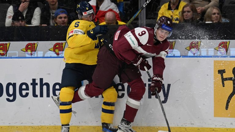 Latvia's Ēriks Mateiko and Sweden's Mattias Hävelid vie for the puck during the IIHF World Junior Championship group A ice hockey match between Sweden and Latvia at Scandinavium in Gothenburg, Sweden, Tuesday, Dec. 26, 2023. (Björn Larsson Rosvall/TT News Agency via AP)