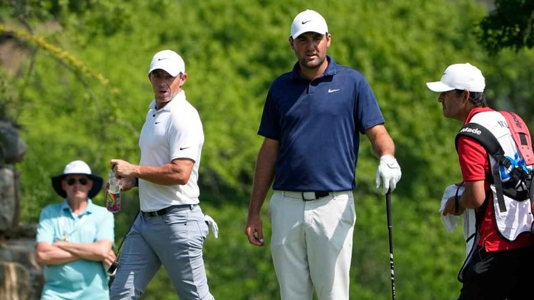 Rory McIlroy, of Northern Ireland, left, and Scottie Scheffler, center, looks at their putting lines on the fifth hole during a consolation match at the Dell Technologies Match Play Championship golf tournament. (Eric Gay/AP)