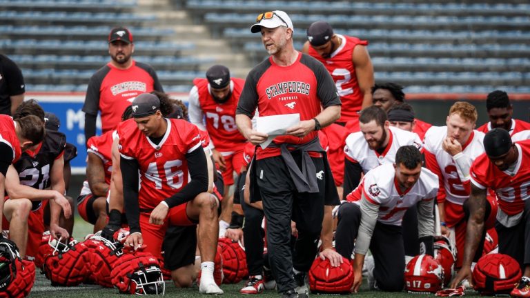 Calgary Stampeders head coach Dave Dickenson, centre right, speaks to players during opening day of training camp in Calgary, Alta., May 12, 2024. (Jeff McIntosh/THE CANADIAN PRESS)