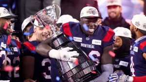 Montreal Alouettes defensive lineman Lwal Uguak (96) poses with the Grey Cup after the Alouettes defeated the Winnipeg Blue Bombers to win the 110th CFL Grey Cup in Hamilton, Ont., on Sunday, November 19, 2023. (Frank Gunn/CP)