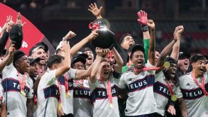 Vancouver Whitecaps' Ryan Gauld, centre, hoists the Voyageurs Cup with his teammates after Vancouver defeated Toronto FC on penalty kicks during the Canadian Championship final soccer match, in Vancouver. (Darryl Dyck/CP)