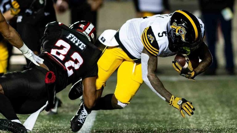 Ottawa Redblacks defensive back Adrian Frye (22) trips up Hamilton Tiger-Cats running back Greg Bell (5) during the first half of regular season CFL action against the Hamilton Tiger-Cats at TD Place in Ottawa, Friday, Oct. 25, 2024. (Spencer Colby/CP)