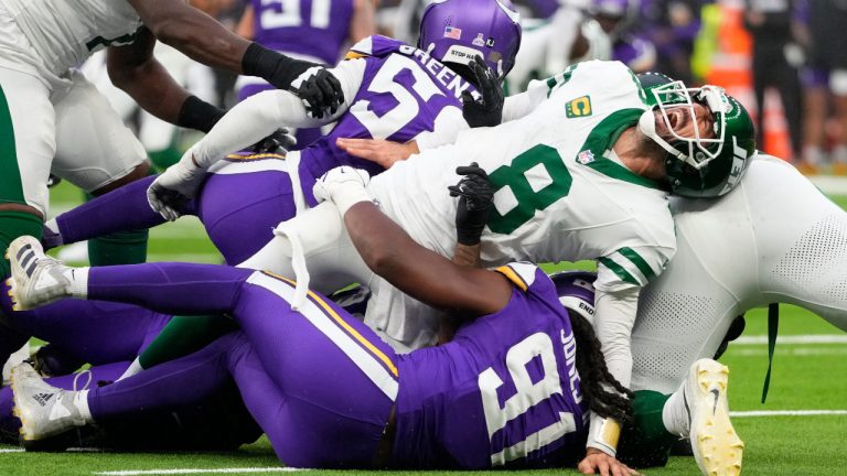 New York Jets quarterback Aaron Rodgers (8), right, reacts as he is tackled during the second half of an NFL football game against the Minnesota Vikings, Sunday, Oct. 6, 2024, at the Tottenham Hotspur stadium in London. (Kirsty Wigglesworth/AP)