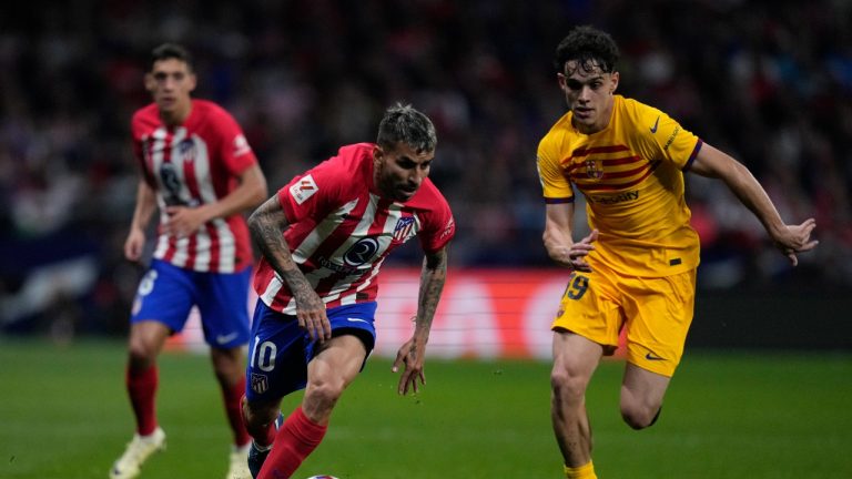 Atletico Madrid's Angel Correa, left, is challenged by Barcelona's Hector Fort during a La Liga soccer match. (AP)